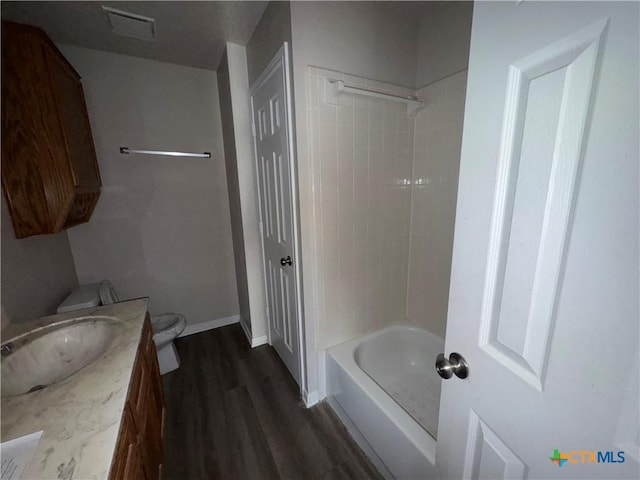 full bathroom featuring vanity, toilet,  shower combination, and hardwood / wood-style flooring