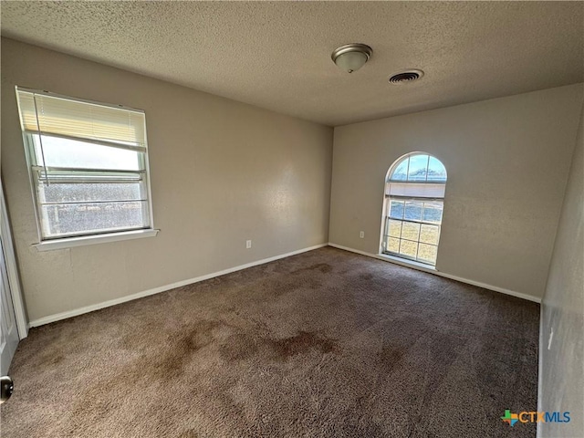 carpeted spare room featuring a textured ceiling