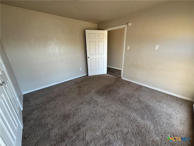 carpeted spare room featuring a textured ceiling