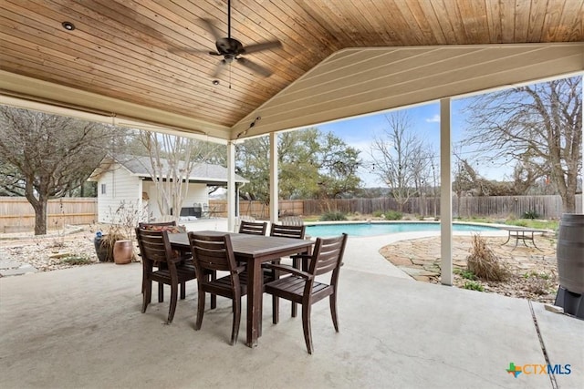 view of patio featuring ceiling fan, an outbuilding, a fenced backyard, and a fenced in pool