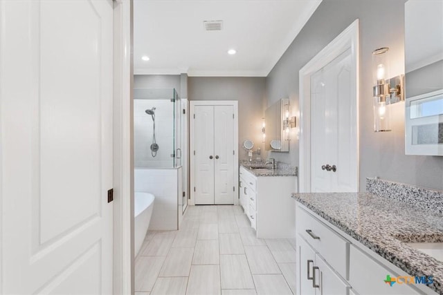 bathroom with two vanities, visible vents, a sink, a shower stall, and a freestanding tub