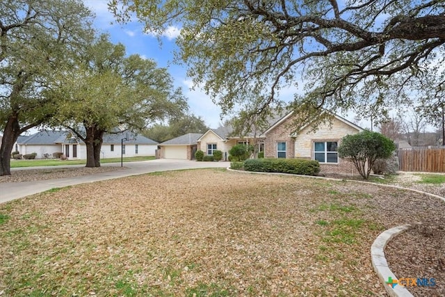 ranch-style home featuring a garage, a residential view, fence, and brick siding