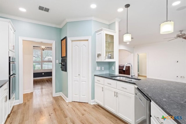 kitchen featuring glass insert cabinets, pendant lighting, white cabinetry, and a sink