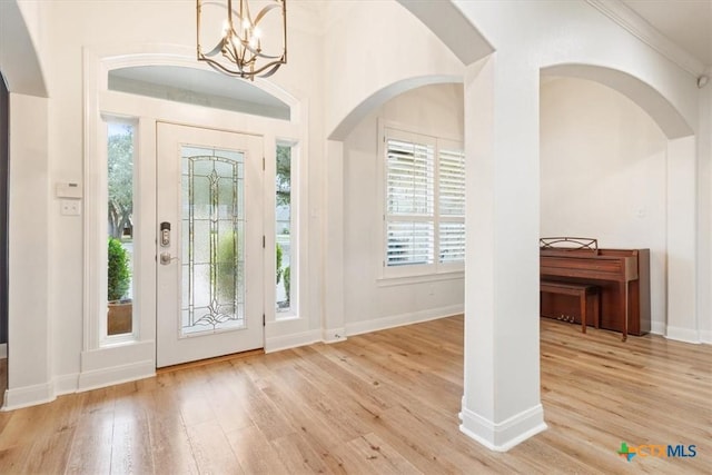 foyer with a chandelier, light wood-style flooring, and baseboards