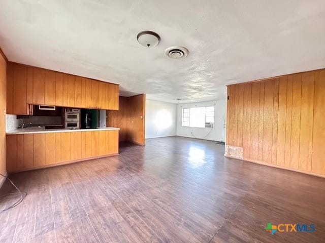 2009 S Laurent St, Victoria, TX 77901 - unfurnished living room featuring wood finished floors and wooden walls