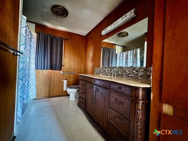 2009 S Laurent St, Victoria, TX 77901 - bathroom with vanity, decorative backsplash, wood walls, and curtained shower