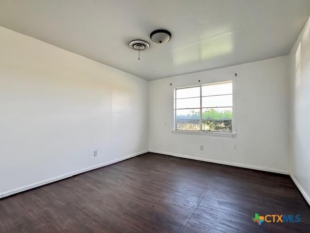 2009 S Laurent St, Victoria, TX 77901 - unfurnished room with baseboards and dark wood-style floors