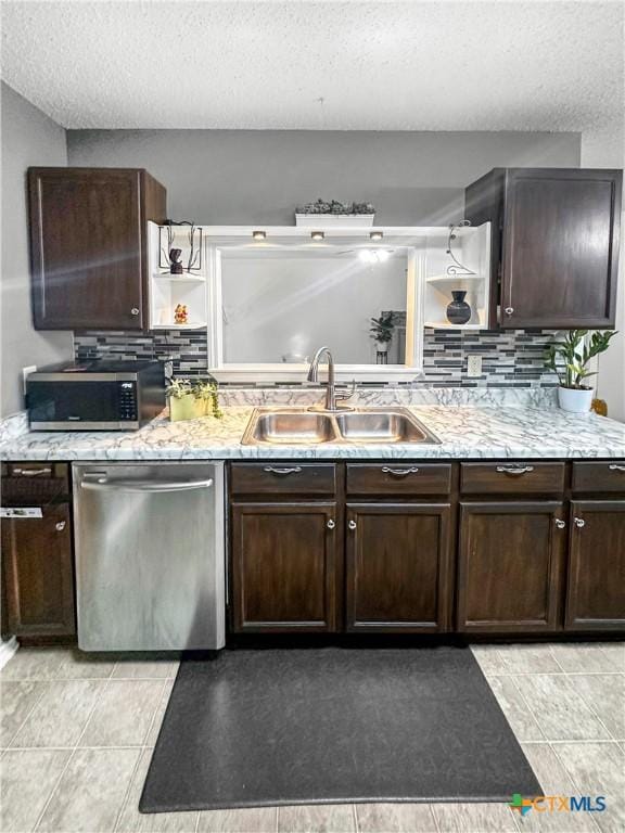 kitchen featuring dark brown cabinetry, appliances with stainless steel finishes, a sink, open shelves, and backsplash