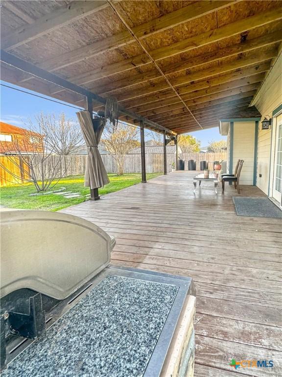 wooden terrace with a fenced backyard