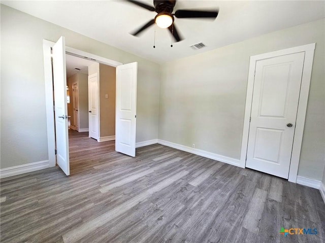 958 E Humphreys St, Seguin, TX 78155 - unfurnished bedroom with wood finished floors and a ceiling fan