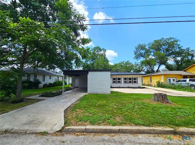 958 E Humphreys St, Seguin, TX 78155 - view of front of house with concrete driveway, a front yard, and a carport