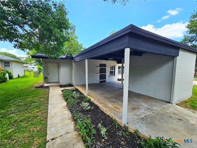 958 E Humphreys St, Seguin, TX 78155 - exterior space featuring a front yard, concrete block siding, a carport, a patio, and concrete driveway