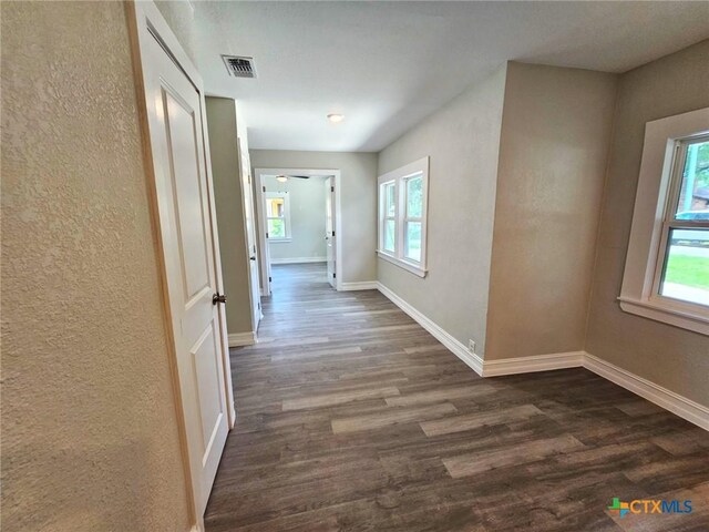 958 E Humphreys St, Seguin, TX 78155 - corridor featuring dark wood finished floors, a textured wall, and baseboards