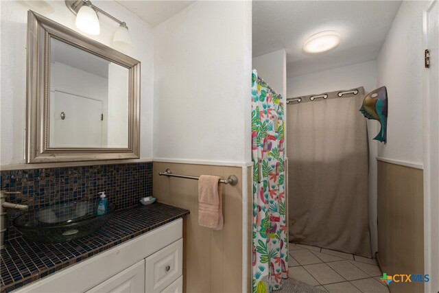 bathroom with backsplash, vanity, tile patterned floors, and curtained shower