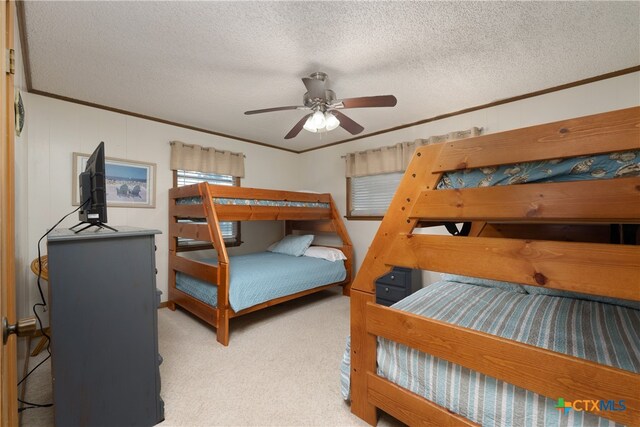 bedroom with ceiling fan, a textured ceiling, crown molding, and light colored carpet