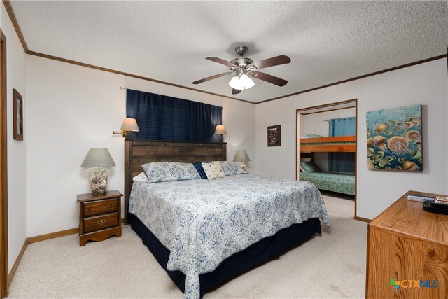 bedroom with a textured ceiling, carpet flooring, ceiling fan, and crown molding