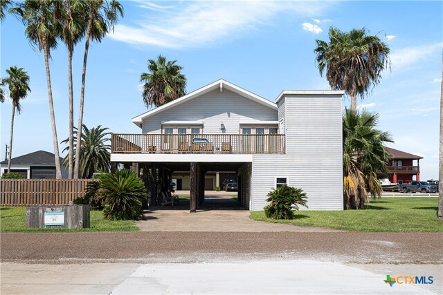 view of front of house with a carport, a front lawn, and a wooden deck