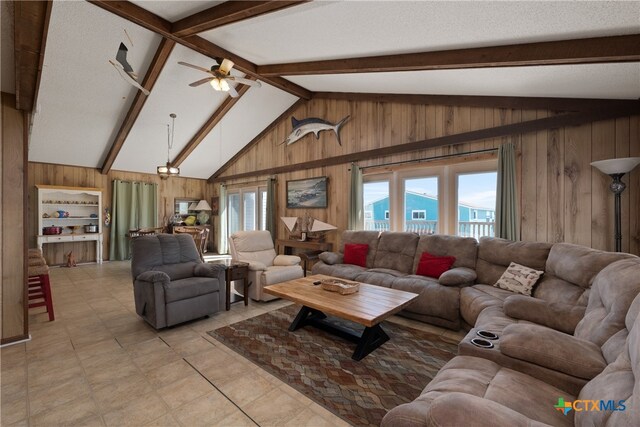 living room featuring wood walls, ceiling fan, beamed ceiling, and a textured ceiling