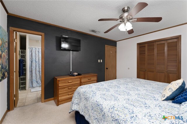 bedroom featuring a textured ceiling, light carpet, ornamental molding, ceiling fan, and a closet