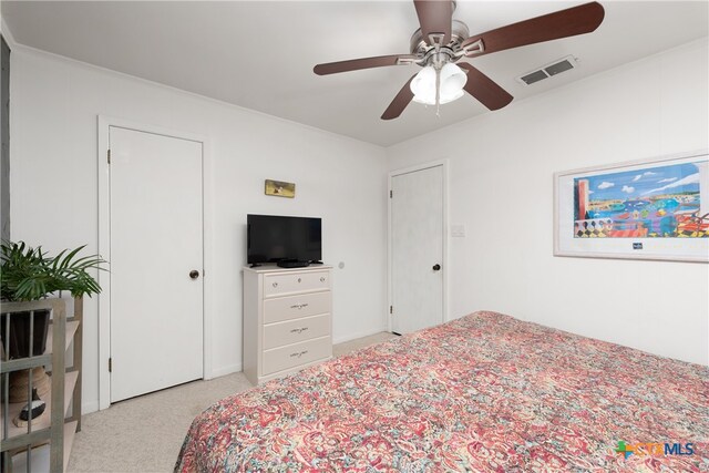 bedroom featuring ceiling fan, light carpet, and crown molding