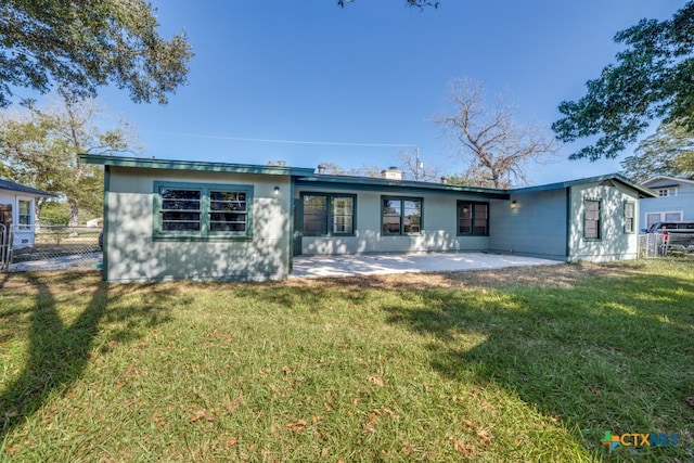 rear view of property featuring a patio and a yard