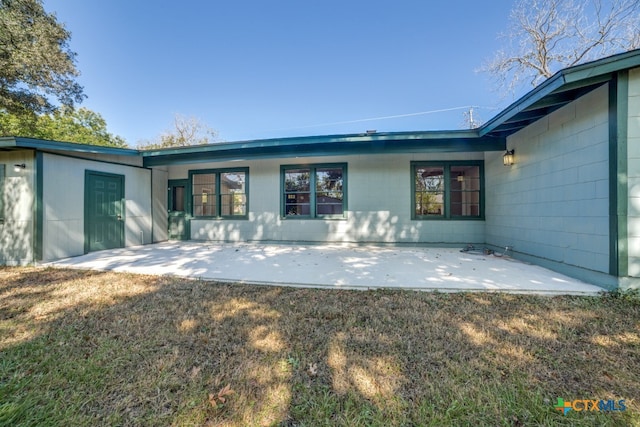 rear view of property featuring a patio and a yard