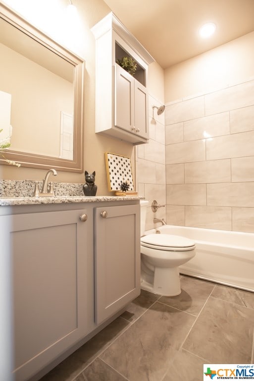 full bathroom with tiled shower / bath, vanity, toilet, and tile patterned flooring