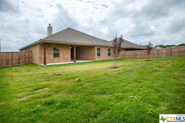 1018 Winchester Dr, Nolanville, TX 76559 - back of house with a chimney, a patio, and brick siding