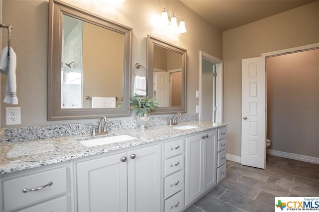1018 Winchester Dr, Nolanville, TX 76559 - bathroom with double vanity, toilet, and baseboards