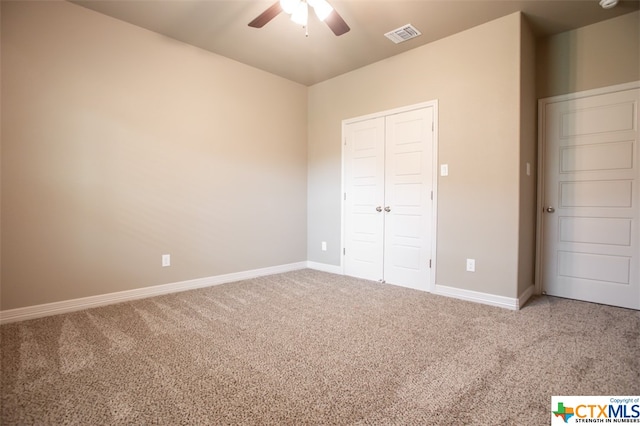 unfurnished bedroom featuring ceiling fan, a closet, and carpet