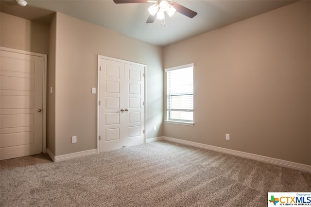 unfurnished bedroom with ceiling fan and carpet