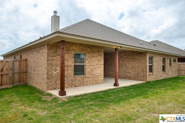 rear view of house with a lawn and a patio