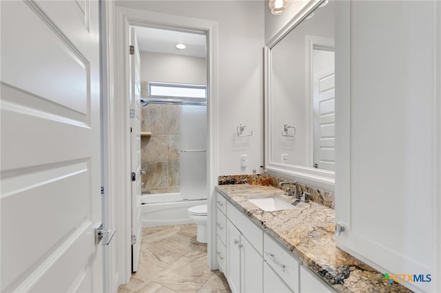 full bathroom with vanity, tiled shower / bath combo, and toilet