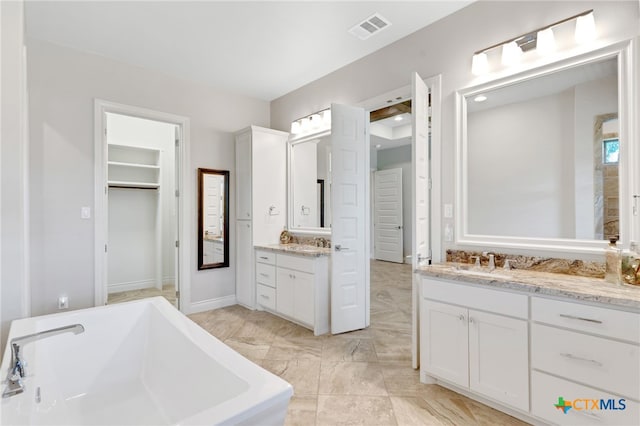 bathroom with vanity and a bath