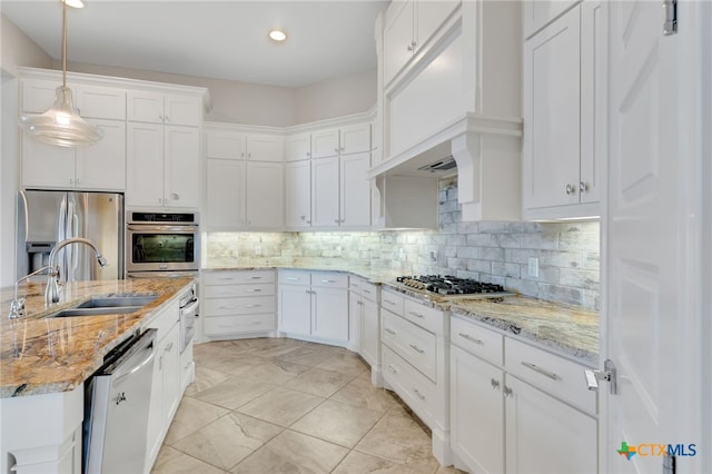 kitchen featuring sink, backsplash, decorative light fixtures, white cabinets, and appliances with stainless steel finishes