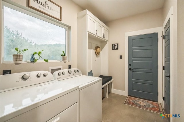 laundry area featuring baseboards, washing machine and dryer, and cabinet space
