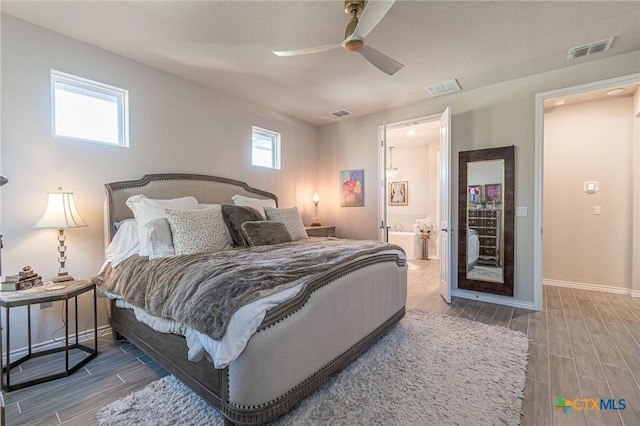 bedroom with wood finish floors, baseboards, ceiling fan, and ensuite bathroom