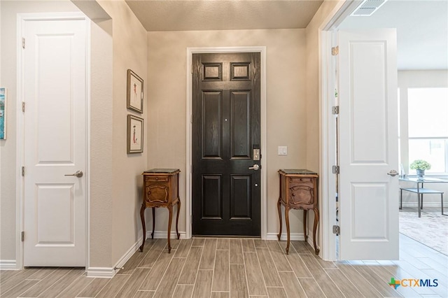 entryway with wood finish floors and baseboards