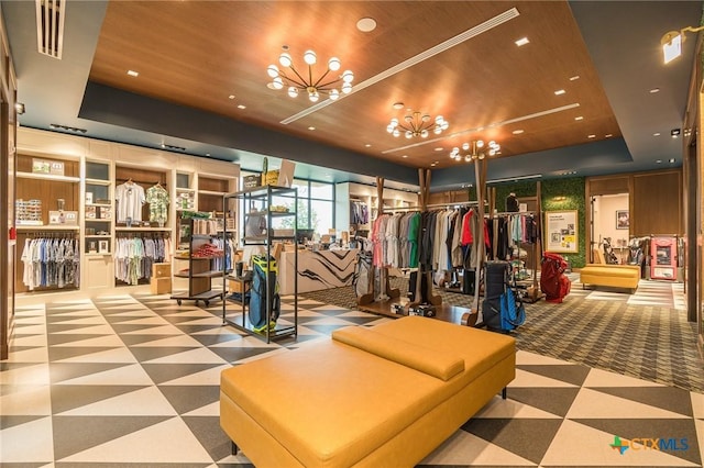 exercise room featuring a chandelier, a raised ceiling, and wood ceiling
