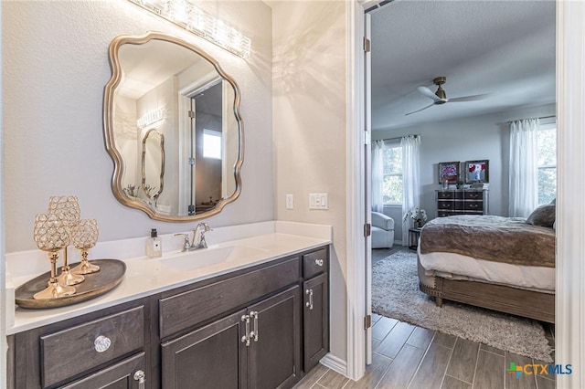 bathroom with connected bathroom, ceiling fan, vanity, and wood tiled floors