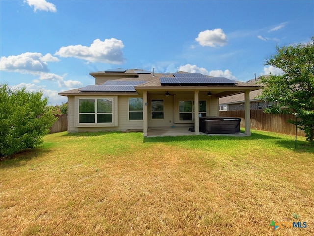 414 Field Corn Ln, San Marcos, TX 78666 - back of house featuring a ceiling fan, a hot tub, a patio area, a fenced backyard, and roof mounted solar panels