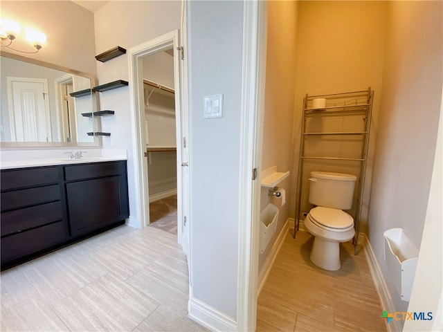 414 Field Corn Ln, San Marcos, TX 78666 - bathroom with vanity, a spacious closet, and wood finished floors