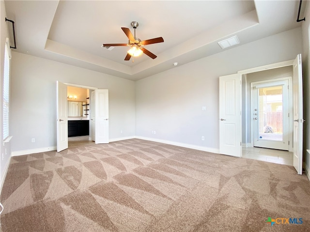 414 Field Corn Ln, San Marcos, TX 78666 - unfurnished bedroom featuring a raised ceiling, light carpet, and ensuite bathroom