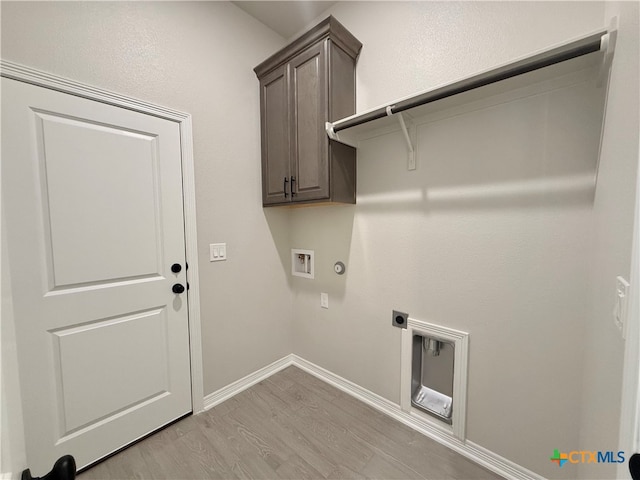 laundry room with gas dryer hookup, hookup for a washing machine, cabinets, electric dryer hookup, and light hardwood / wood-style flooring