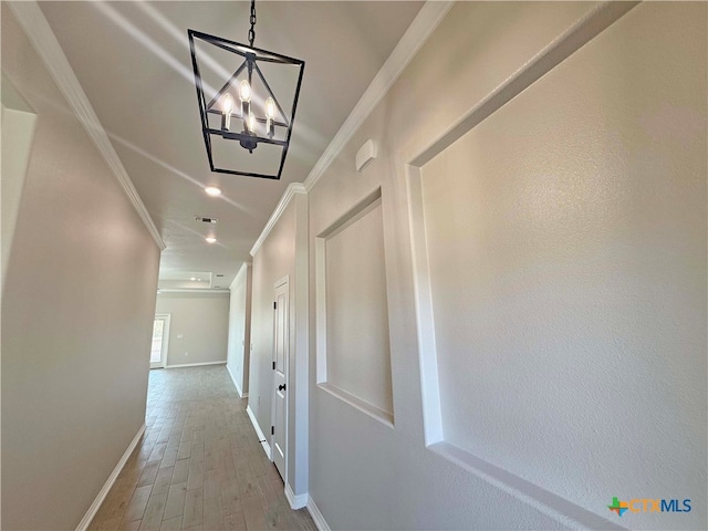 corridor featuring hardwood / wood-style floors, a notable chandelier, and ornamental molding