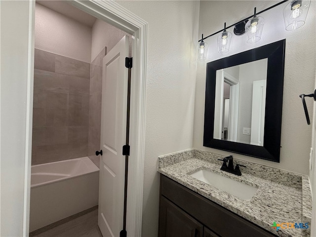 bathroom with vanity and tiled shower / bath