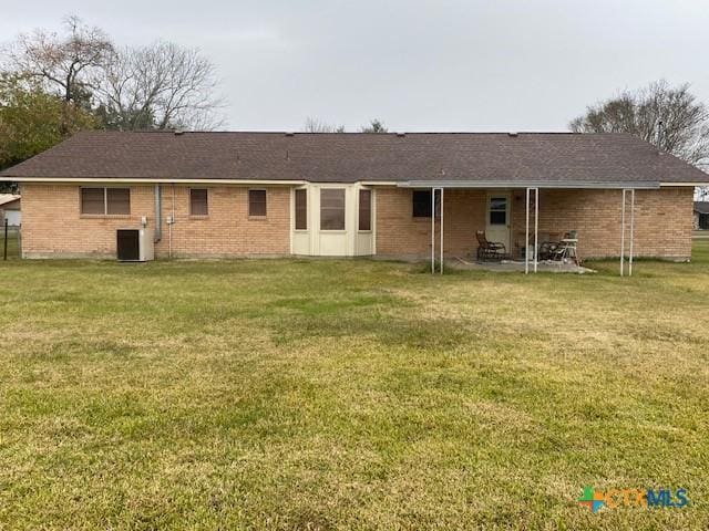 rear view of house with a yard and cooling unit