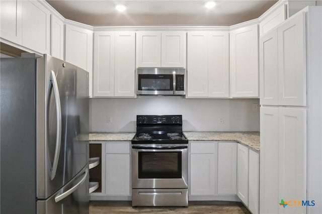 608 E 13th Ave, Belton, TX 76513 - kitchen with stainless steel appliances, white cabinets, light stone countertops, recessed lighting, and wood finished floors