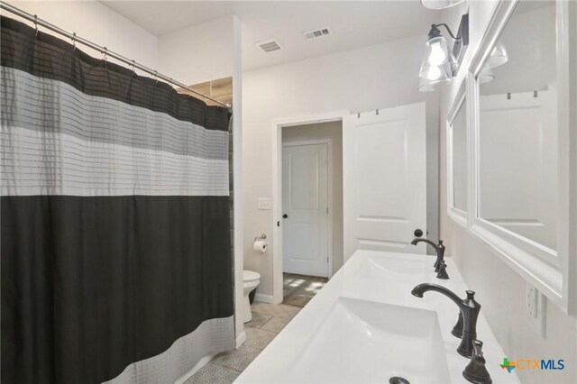 608 E 13th Ave, Belton, TX 76513 - full bathroom with double vanity, a shower with curtain, and tile patterned flooring