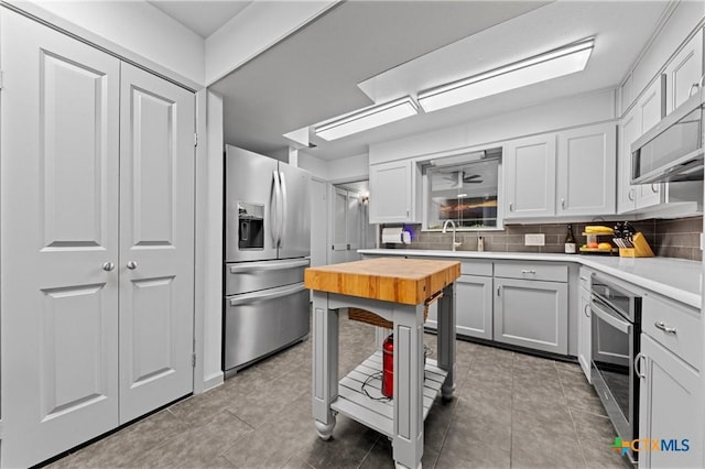 3921 Cripple Creek Dr, Temple, TX 76502 - kitchen with stainless steel appliances, butcher block countertops, backsplash, and tile patterned flooring